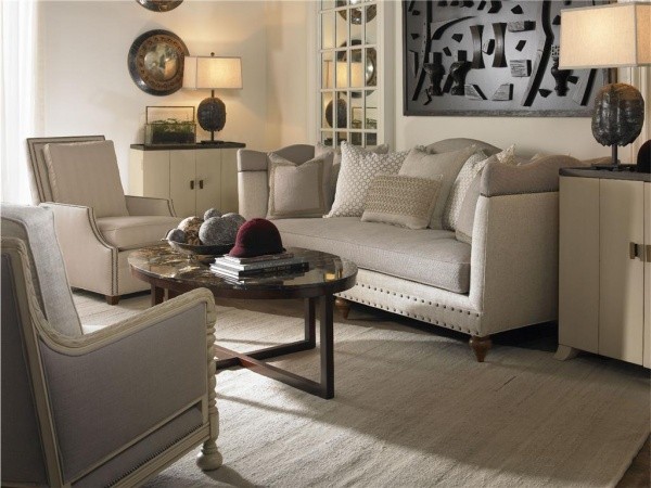 luxury living room featuring grey and cream furniture with dark wood round table and light grey rug