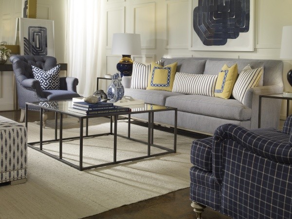 luxury living room featuring grey sofa, large square metal table, blue chairs and cream area rug