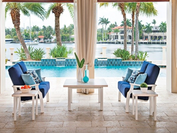 luxury patio including  blue chairs with blue pillows and white wooden square table and square end tables