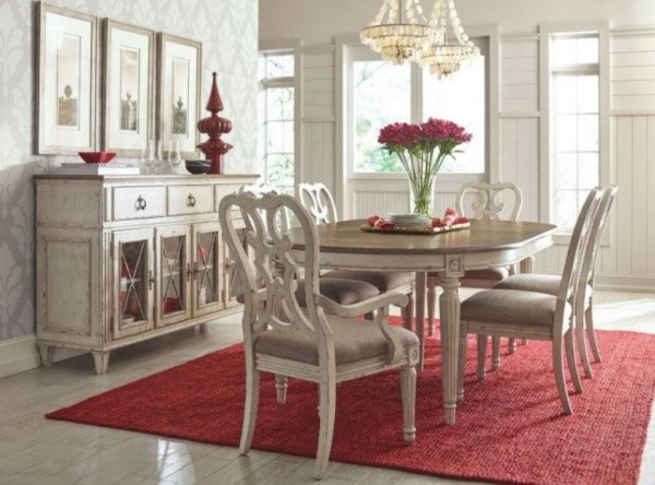 luxury dining room with light brown antiqued dining room table with 6 chairs and red area rug and accents