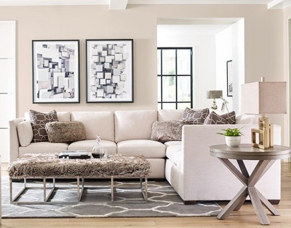luxury living room featuring white wraparound sofa with brown table, grey honeycomb pattern rug and round wooded end table