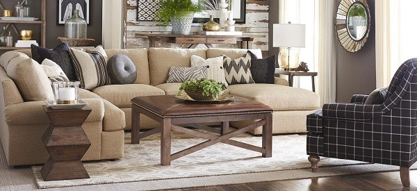luxury living room featuring a tan sofa with multiple pillows, a wooden table, and a plaid chair