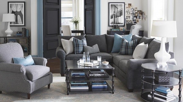 luxury living room featuring grey sofa and chairs with multiple teal pillows, metal tables, and grey and teal color scheme