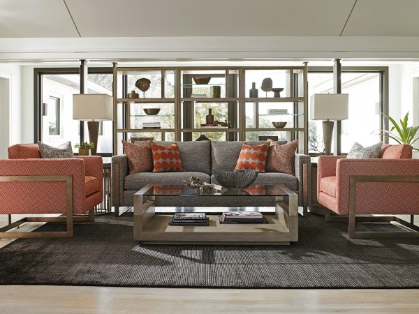 luxury living room featuring grey and orange color scheme with grey sofa and two orange patterned chairs with grey area rug