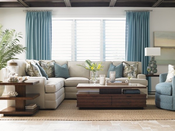 luxury living room featuring off white sofa with wooden furniture, tan rug and light blue chair