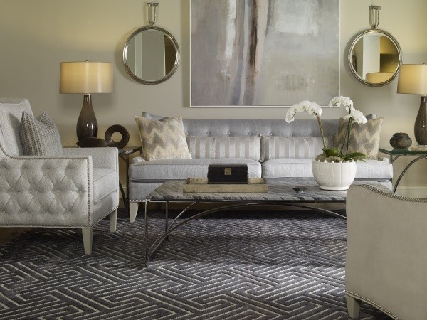 luxury living room featuring metallic silver couch with grey patterned rug with light grey chairs