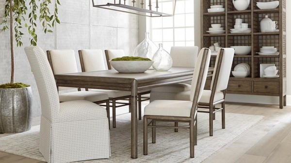 luxury dining room with predominantly white color scheme with brown wooden table and brown and white chairs with white rug