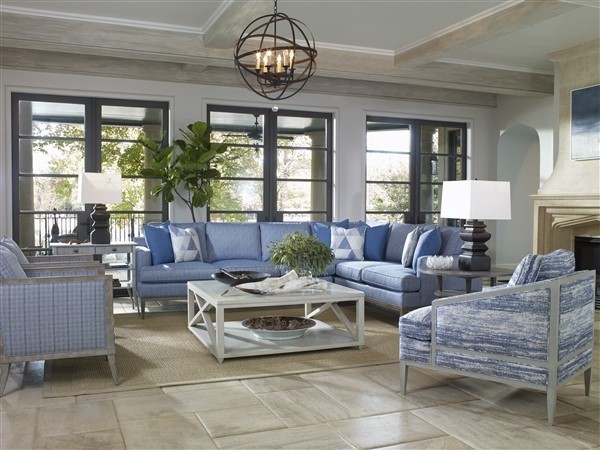 luxury living room featuring blue furniture with white table on a tan rug
