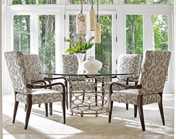 luxury dining room with grey and white patterned chairs and a round metal table with white accents