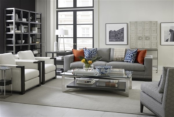 luxury living room featuring grey sofas and chair, white chairs, and glass top table on a grey area rug
