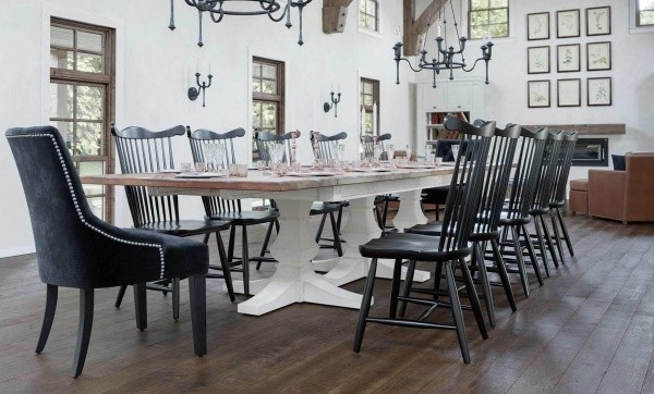 luxury dining room with large white wooden table with twelve black wooden chairs