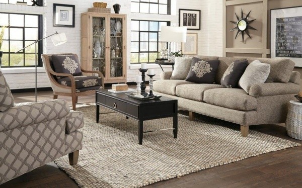 luxury living room featuring grey color scheme with grey couch with pillows, black wooden table, multiple grey chairs and grey rug