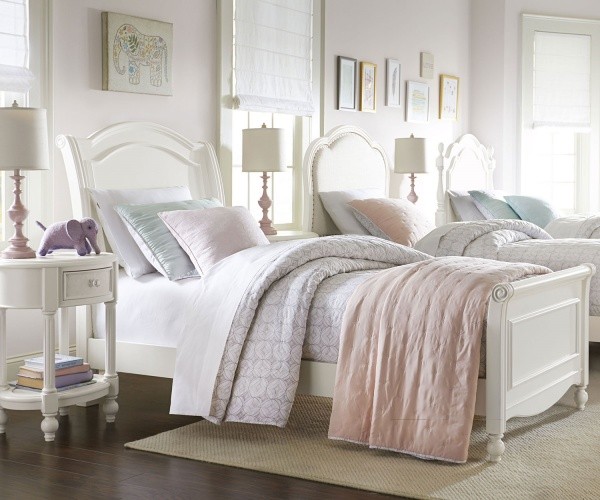 luxury finished interior bedroom with three beds done in pastels with white wood bed frames and furniture