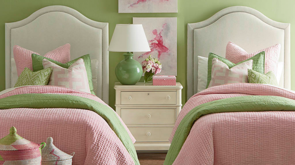 luxury finished interior secondary suite with two beds with pink green and white color scheme and off white nightstand with green lamp