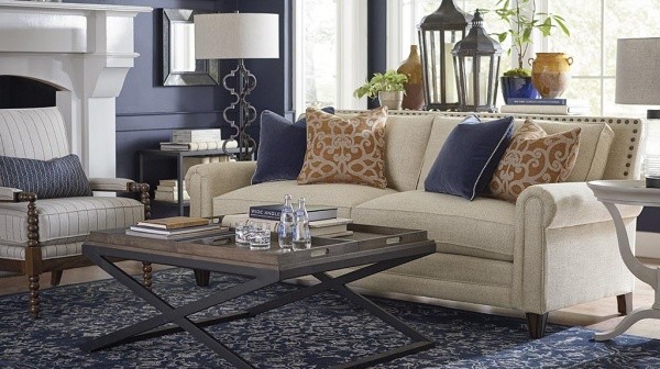 luxury living room featuring a blue and white color scheme with tan couch, white striped chair and wooden coffee table