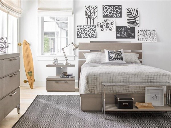 luxury finished interior with grey color scheme including grey bed frame and bedding, grey furniture and art