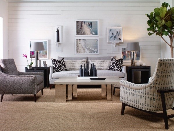 luxury living room featuring white and grey furniture with light brown carpeting with black end tables