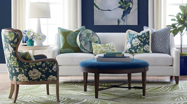 luxury living room featuring floral patterns, and a blue and white color scheme with white sofa, blue floral print chair and and blue round table