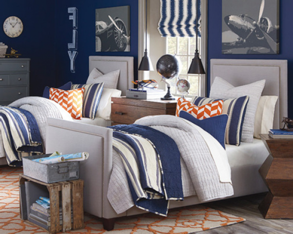 luxury finished interior secondary suite with two beds and wooden furniture. Blue, white and orange color scheme with airplane theme
