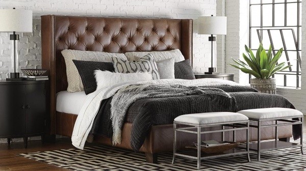luxury home furniture master bedroom with brown leather bed frame and white, black and grey bedding with black furniture