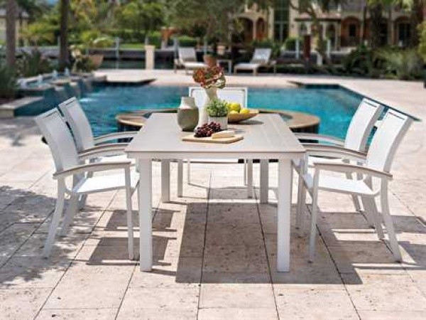 luxury patio including white wood dining table and 5 white chairs overlooking the pool