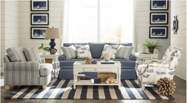 luxury living room featuring blue and white color scheme with blue sofa and two blue patterned chairs with striped white and blue rug with white table