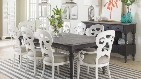 luxury dining room with black and grey table with white and cream chairs with striped white and black rug